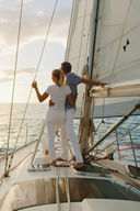 Old couple standing at bow of sailboat